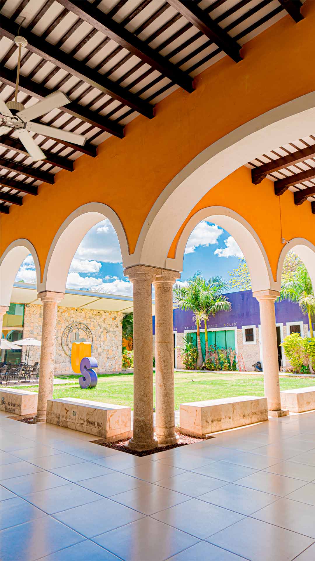 Patio de Universidad del Sur visto desde sus arcos, con los colores de la universidad